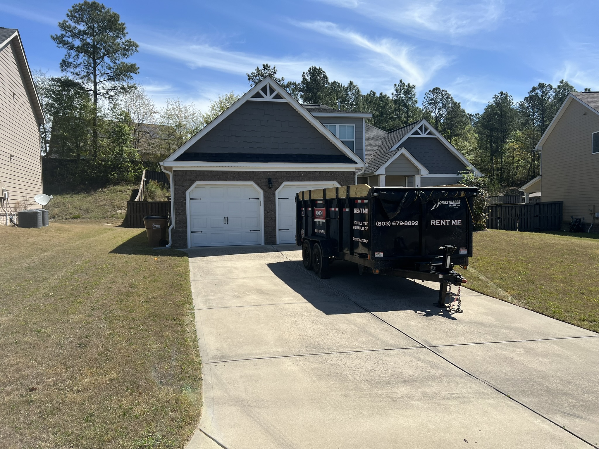 Aiken Dumpster Rentals rubber-wheeled trailer on a clean residential driveway