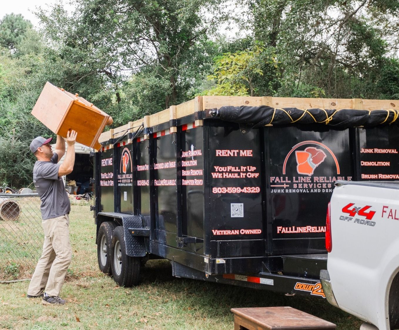 Loading furniture and household items into a rental dumpster trailer in Aiken SC