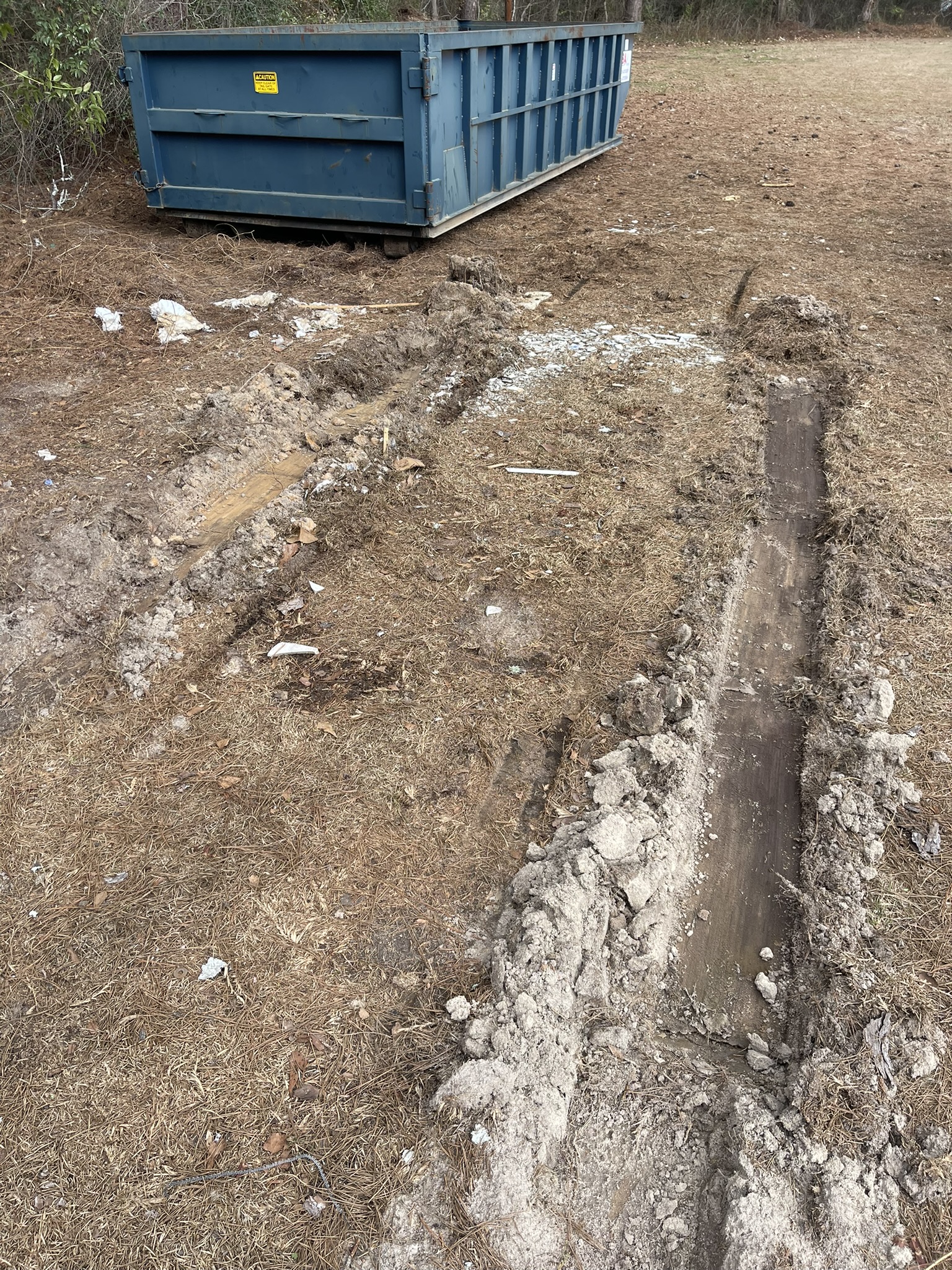 Deep ground ruts from traditional roll-off dumpster delivery