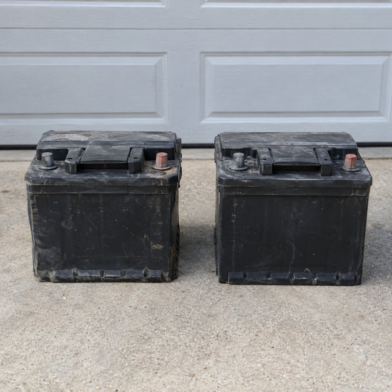 Car batteries set beside a dump trailer