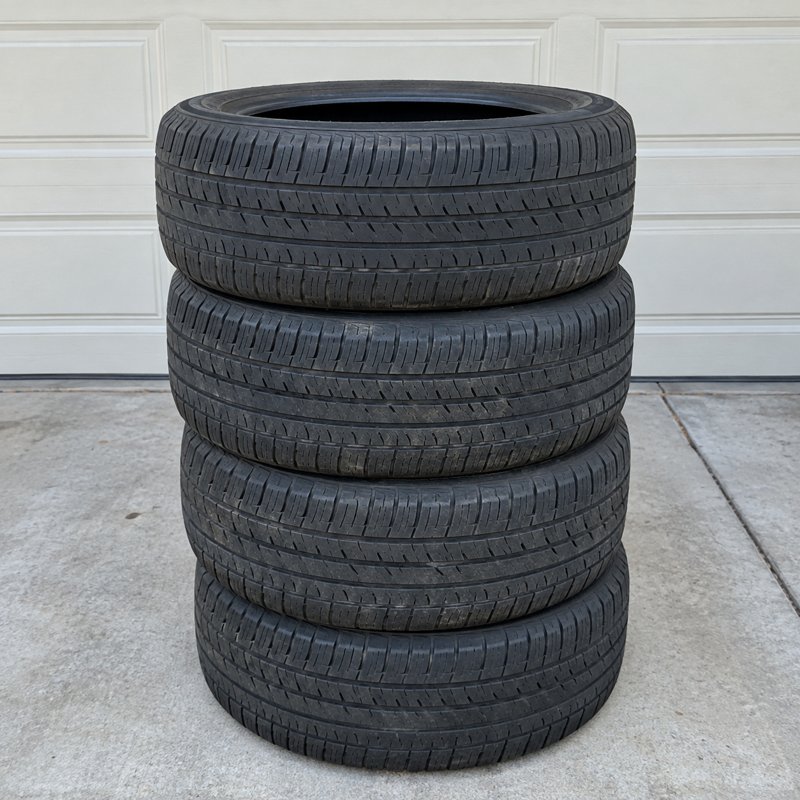 Used tires stacked beside a dump trailer